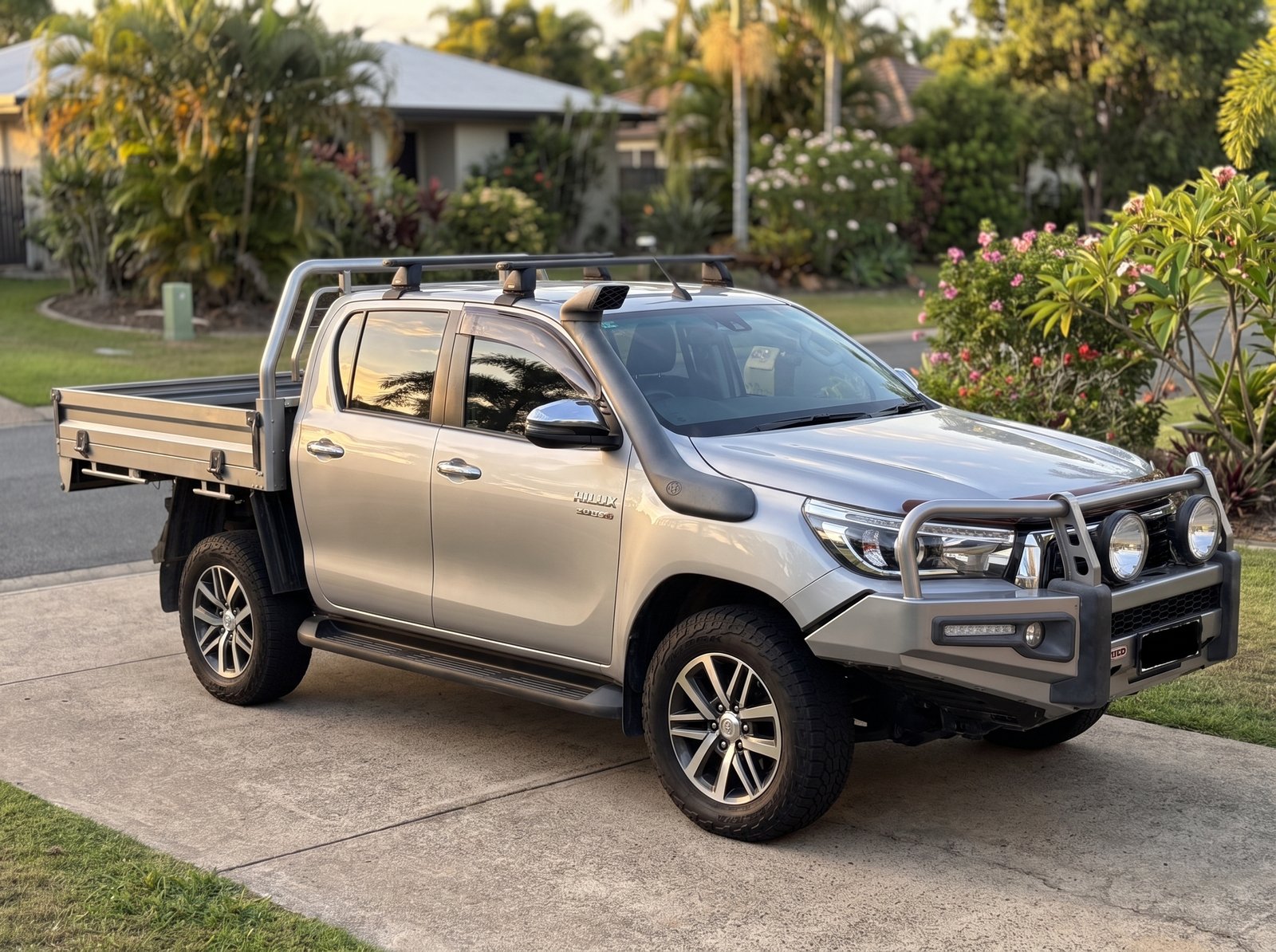 Silver Toyota HiLux with tray and bull bar, side view
