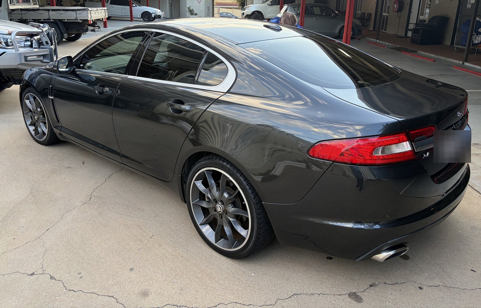 Rear three-quarter view of a detailed dark grey Jaguar XF